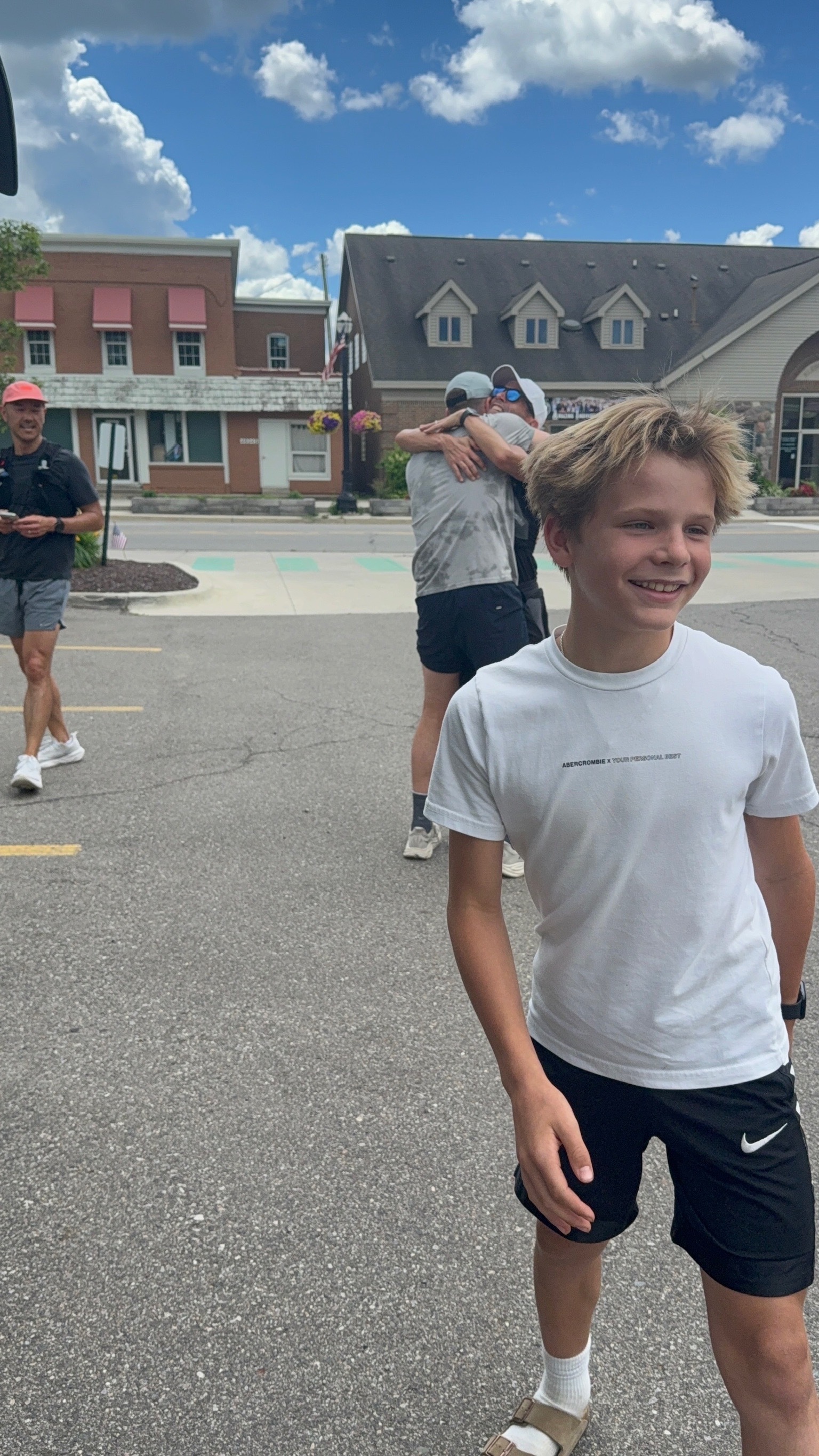 Garrett smiling, Ryan and DJ hugging in the background